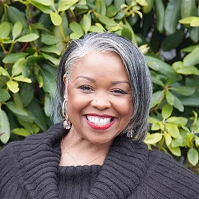 Hansen Dentistry Staff Member Tammy Smiling In Front Of Shrub